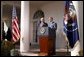 As Secretary of State Colin Powell stands by his side, President George W. Bush addresses the media in the Rose Garden Friday, March 14, 2003. White House photo by Paul Morse