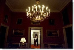 Viewed from the Red Room, President George W. Bush addresses the nation from the Cross Hall in the White House Monday evening, March 17, 2003.  White House photo by Eric Draper