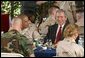 President George W. Bush sits down for lunch with military personnel at MacDill Air Force Base in Tampa, Florida, Wednesday, March 26, 2003. White House photo by Paul Morse