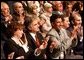 Standing at the far right, Haider Al-Jebori, President of the Steering Committee for Iraqi Home Culture, applauds for President George W. Bush at the Ford Community and Performing Arts Center in Dearborn, Mich., Monday, April 28, 2003. White House photo by Tina Hager