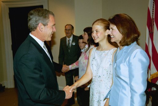 President George W. Bush greets Elizabeth Smart, center, and her mother Lois Smart in the Roosevelt Room Wednesday, April 30, 2003. President Bush met with the Smart family before the signing of the S. 151, PROTECT Act of 2003. White House photo by Eric Draper