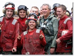 President George W. Bush poses with flight deck crew of the USS Abraham Lincoln May 1, 2003. White House photo by Paul Morse