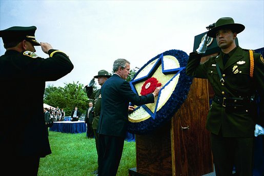 President George W. Bush places a flower on a memorial wreath during the Annual Peace Officers' Memorial Service at the U.S. Capitol Washington, D.C., Thursday, May 15, 2003. White House photo by Paul Morse.