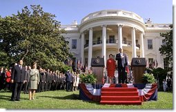 President Bush, President Arroyo, Mrs. Bush and Mr. Arroyo (far left) stand for the playing of the national anthems of the United States and the Philippines at the beginning of the ceremony.   White House photo by Eric Draper