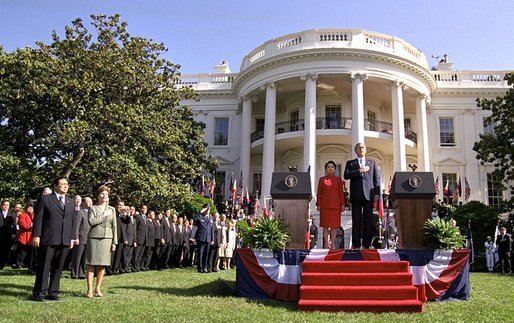 President Bush, President Arroyo, Mrs. Bush and Mr. Arroyo (far left) stand for the playing of the national anthems of the United States and the Philippines at the beginning of the ceremony. White House photo by Eric Draper