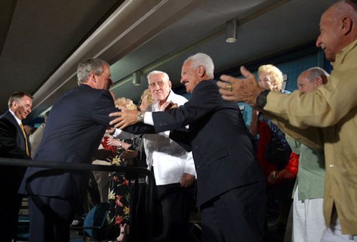 President George W. Bush and Health & Human Services Secretary Tommy Thompson, left, greet seniors at the Little Havana Activities and Nutrition Center in Miami, Fla., June 30, 2003. White House photo by Paul Morse