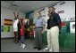 President George W. Bush watches an exercise class during a tour of Lakewest Family YMCA in Dallas, Texas, Friday, July 18, 2003. Also pictured, at far right, are Lynn Swann, Chairman of the President's Council on Physical Fitness and Sports and YMCA Volunteer Andrews Simpson. White House photo by Paul Morse