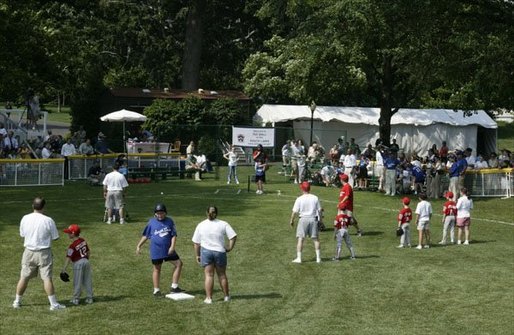 The bases are loaded with Tee-Ball players and their buddies during this season's second game of the White House South LawnTee-Ball League Sunday, July 27, 2003. Teams and families from Glen Burnie, Md., and Ridley Park, Pa., came out for tee-ball and picnic on the South Lawn. White House photo by Lynden Steele.