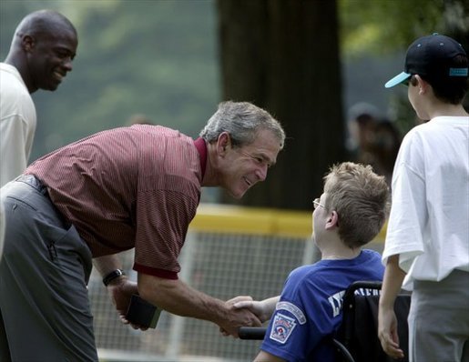 After a game of cheers and close calls, President George W. Bush and Washington Redskin star Darrel Green greet each player with handshakes and an autographed baseball during a ceremony for the White House South Lawn Tee-Ball League Sunday, July 27, 2003. White House photo by Lynden Steele.