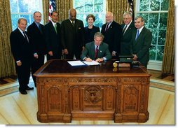 President George W. Bush signs into law, H.R. 13, the Museum and Library Services Act of 2003, in the Oval Office Thursday, Sept. 25, 2003. Pictured with the President are, from left: Congressman Ralph Regula, R-Ohio; Congressman Peter Hoekstra, R-Mich., Congressman John Boehner, R-Ohio., Education Secretary Rod Paige, Laura Bush, Dr. Robert Martin, Director of the Institute of Museum and Library Services; Senator Mike Enzi, R-Nev.; and Senator Jack Reed, D-R.I.  White House photo by Tina Hager