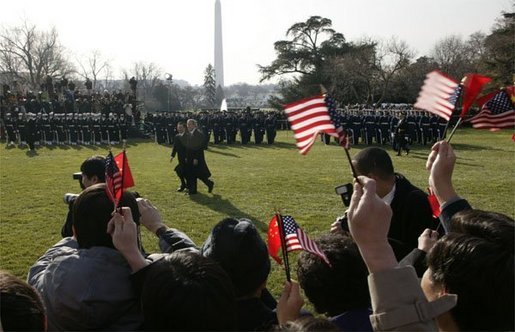 President George W. Bush and Premier Wen Jiabao of China wave to well-wishers during an Arrival Ceremony on the South Lawn Tuesday, Dec. 9, 2003. "America and China share many common interests. We are working together in the war on terror. We are fighting to defeat a ruthless enemy of order and civilization. We are partners in diplomacy working to meet the dangers of the 21st century. We are full members of a world trading system that rewards enterprise and lifts nations," said President Bush in his remarks. White House photo by Paul Morse