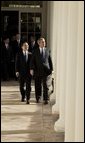 After the Arrival Ceremony, President George W. Bush and Premier Wen Jiabao of China walk along the Rose Garden Colonnade on their way to the Oval Office Tuesday, Dec. 9, 2003. "We're going to have extensive discussions today on a lot of issues," said the President during an Oval Office meeting with the media. "We've just had a very friendly and candid discussion. There's no question in my mind that when China and the United States works closely together we can accomplish a lot of very important objectives."  White House photo by Paul Morse