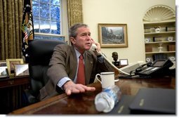 President George W. Bush speaks with British Prime Minister Tony Blair during a phone call in the Oval Office, Sunday morning, Dec. 14, 2003.  White House photo by Eric Draper