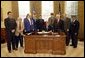 President George W. Bush signs H. R. 2297, the Veterans Benefits Act of 2003, in the Oval Office Tuesday, Dec. 16, 2003. The act expands the benefits program for veterans and their surviving spouses. In attendance are, from left: veterans Dave Thornton of Haymarket, Va.; Charles Stenger of Bethesda, Md.; Carol Near of East Moline, Ill.; Congressman Rob Simmons, R-Conn.; Congressman Chris Smith, R-N.J.; Congressman Lane Evans, D-Ill.; Congressman Henry Brown, R-S.C.; Congressman Bob Filner, D-Calif.; and veteran Guillermo Rumingan of Arlington, Va. White House photo by Paul Morse.