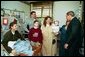 President George W. Bush embraces the mother-in-law of U.S. Army Staff Sergeant Roy Mitchell, who is at left, as other family members look on during the President’s visit to Walter Reed Army Medical Center in Washinton, D.C., Thursday, December 18, 2003. President Bush had just presented Sgt. Mitchell The Purple Heart for injuries sustained while serving in Iraq. Sgt. Mitchell is from Milan, Indiana. Others present are, from left, Jerry Stoneking, Zachary Bice and Sgt. Mitchell's wife, Michelle, who is holding their son Jerrett. White House photo by Eric Draper