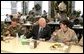 During lunch with troops from McChord Air Force Base and Fort Lewis, Vice President Dick Cheney talks with Capt. Lyn Marm, right, and Senior Airman Jose L. Negron, left, at McChord Air Force Base, Wash., Dec. 22, 2003. Prior to lunch, Vice President Cheney addressed the troops and presented the Bronze Star to Maj. Brian Robinson and The Purple Heart to Spc. Justin L. Anderson and Sgt. Johnie L. Smith. Vice President Cheney presented Air Medals to Capt. Paul Sontein, Capt. Anne R. Lueck, 1st Lt. Andrew D. Oiland, Tech. Sgt. James S. Alexander and Staff Sgt. Eric M. Olsen. White House photo by David Bohrer.