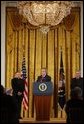 President George W. Bush addresses The National Catholic Educational Association in the East Room Friday, Jan. 9, 2004. Pictured with the President are Bishop Gregory Aymond of Austin, Texas, left and Michael Guerra, President of the NCEA. White House photo by Tina Hager