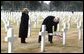 Vice President Dick Cheney places a rose on the grave of Wyoming solider Sgt. John Vannoy while touring the Sicily-Rome American Cemetery with his wife, Lynne, in Nettuno, Italy Jan. 26, 2004. The cemetery inters those who gave their life for the liberation of Italy during World War II. White House photo by David Bohrer