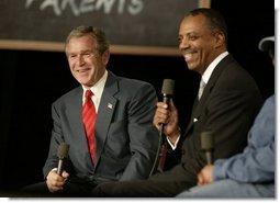 President George W. Bush and John Butler, President of Archbishop Carroll High School, listen to the audience during a conversation on parental options and school choice at Archbishop Carroll High School in Washington, D.C., Friday, Feb. 13, 2004.  White House photo by Paul Morse