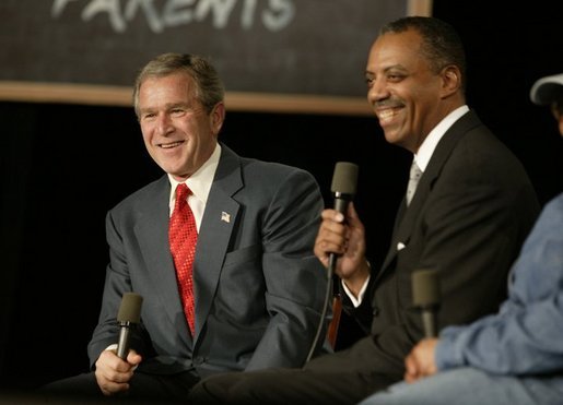 President George W. Bush and John Butler, President of Archbishop Carroll High School, listen to the audience during a conversation on parental options and school choice at Archbishop Carroll High School in Washington, D.C., Friday, Feb. 13, 2004. White House photo by Paul Morse