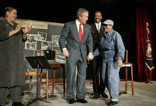 President George W. Bush greets Catherine Hill, who is an aunt and grandparent of D.C. students, after participating in a conversation on parental options and school choice at Archbishop Carroll High School in Washington, D.C., Friday, Feb. 13, 2004. White House photo by Paul Morse