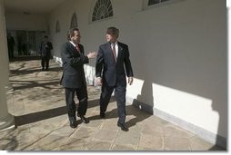 German Chancellor Gerhard Schroeder walks with President George W. Bush along the colonnade in the Rose Garden Friday, Feb. 27, 2004.  White House photo by Eric Draper