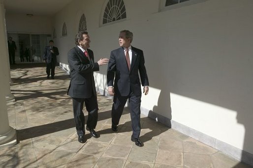 German Chancellor Gerhard Schroeder walks with President George W. Bush along the colonnade in the Rose Garden Friday, Feb. 27, 2004. White House photo by Eric Draper