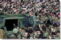 President George W. Bush and Laura Bush are welcomed by military personnel, including the 101st Airborne Division, at Fort Campbell, Ky., Thursday, March 18, 2004. "Fort Campbell was the first army post I visited in the weeks after our country was attacked," said the President during his remarks. Continuing his remarks, the President said, "Since we last met, you deployed over 5,000 vehicles, 254 aircraft, and 18,000 soldiers in Kuwait, in the fastest deployment in the history of the 101st."   White House photo by Tina Hager