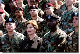 Laura Bush listens while President George W. Bush delivers his remarks at Fort Campbell, Ky., Thursday, March 18, 2004. "Since we last met, you helped to build medical clinics and to rebuild schools. By your decency and compassion, you are helping the Iraqi people to reclaim their country. Because you care, you're helping the Iraqis live as free people," said the President.  White House photo by Tina Hager