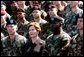 Laura Bush listens while President George W. Bush delivers his remarks at Fort Campbell, Ky., Thursday, March 18, 2004. "Since we last met, you helped to build medical clinics and to rebuild schools. By your decency and compassion, you are helping the Iraqi people to reclaim their country. Because you care, you're helping the Iraqis live as free people," said the President. White House photo by Tina Hager