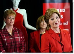 During a trip to Chicago, Mrs. Bush discusses the Red Dress Project Tuesday, March 23, 2004. Behind Mrs. Bush are dresses designed by American fashion designers which are touring the country to raise awareness of heart disease in women.  White House photo by Tina Hager