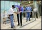 President George W. Bush uses a drill to connect a metal wall frame during a tour of the Carpenters Training Center in Phoenix, Ariz., Friday, March 26, 2004. White House photo by Eric Draper