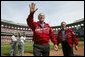 After throwing out the first pitch during the St. Louis Cardinals’ season opener against the Milwaukee Brewers, President George W. Bush waves to the crowd as he walks off the field holding his pitched baseball Monday, April 5, 2004. White House photo by Eric Draper