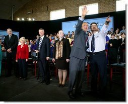 President George W. Bush waves to the audience with student Tony Johnson after a conversation on job training and the economy at South Arkansas Community College in El Dorado, Ark., Tuesday, April 6, 2004.   White House photo by Eric Draper