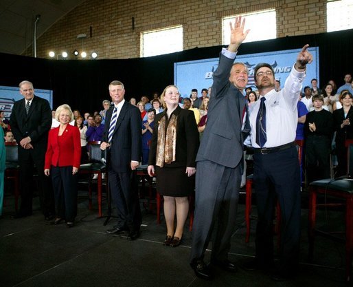 President George W. Bush waves to the audience with student Tony Johnson after a conversation on job training and the economy at South Arkansas Community College in El Dorado, Ark., Tuesday, April 6, 2004. White House photo by Eric Draper