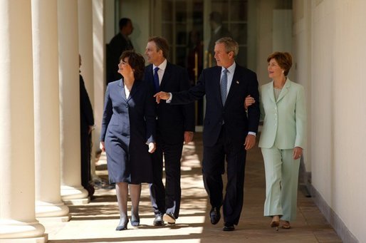 President George W. Bush and Prime Minister Tony Blair walk along the colonnade with their wives Mrs. Laura Bush and Mrs. Cherie Blair after a press conference in the Rose Garden of the White House on April 16, 2004. White House photo by Paul Morse.