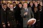 After being presented with a team-signed football, President George W. Bush throws it to an aide during the presentation of the Commander-In-Chief Trophy to the U.S. Naval Academy football team in the East Room Monday, April 19, 2004. The trophy is awarded to the Service Academy with the year's best overall record in NCAA football games versus the other academies. White House photo by Tina Hager.