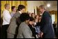 President George W. Bush greets breast cancer survivors at a reception for the National Race for the Cure in the East Room of the White House on April 21, 2004. White House photo by Paul Morse