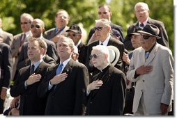 President George W. Bush sings the National Anthem with World War II veterans during the dedication of at the National World War II memorial on the Mall in Washington, DC on May 30, 2004. White House photo by Paul Morse