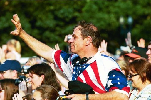 People lined along Constitution Avenue wave to Nancy Reagan as she passes by during the funeral procession of former President Ronald Reagan, Wednesday, June 9, 2004. White House photo by Joyce Naltchayan.