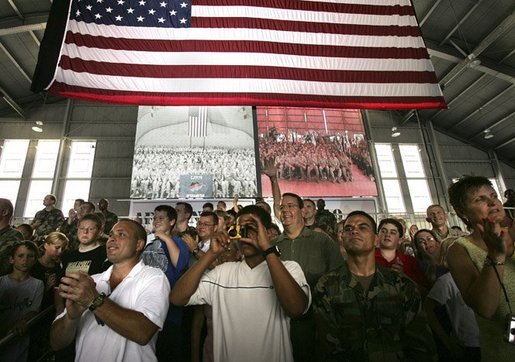 MacDill Air Force Base mIlitary personnel listen to President George W. Bush deliver remarks as two screens display a live feed of military personnel in Afghanistan, left, and Iraq, Wednesday, June 16, 2004. White House photo by Eric Draper.