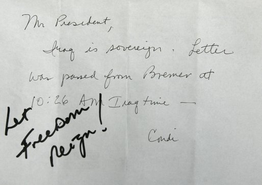 President George W. Bush receives confirmation of Iraqi sovereignty, then wrote, “Let Freedom Reign!,” during the opening session of the NATO Summit in Istanbul, Turkey, Monday, June 28, 2004. White House photo by Eric Draper.