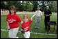 A player from the Challenger Phillies from Middletown, Delaware celebrates receiving a baseball from President George W. Bush and Cal Ripken Jr. at Tee Ball on the South Lawn at the White House on Sunday July 11, 2004. White House photo by Paul Morse.