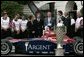 After being presented a racing helmet, President George W. Bush talks with Buddy Rice (center, left), the winner of 2004 Indianapolis 500, and his championship team, Rahal/Letterman Racing, during a visit to the South Lawn of the White House, July 19, 2004. White House photo by Paul Morse.