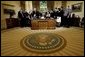 President George W. Bush delivers a Live Radio Address surrounded by Mrs. Bush and families of victims of 911 in the Oval Office, Saturday, Sept. 11, 2004. White House photo by Eric Draper