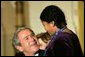 President George W. Bush and Laura Bush join dozens of children to watch a puppet show during the annual Children's Christmas Program in the East Room of the White House, Monday, Dec. 6, 2004. White House photo by Susan Sterner