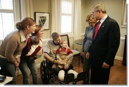 President George W. Bush and Laura Bush talk with U.S. Army Sgt. Dale Beatty of Statesville, N.C., and, from left, sister-in-law Wendolyn Summers, wife Belinda Beatty, son Lucas, 6 months old, and son Dustin, 2 years old, during a visit to the Fisher House at Walter Reed Army Medical Center in Washington, D.C., Tuesday, Dec. 21, 2004. President Bush presented Sgt. Beatty The Purple Heart for injuries he sustained while serving in Operation Iraqi Freedom.  White House photo by Paul Morse