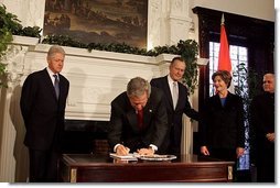 President George W. Bush signs a condolence book for the victims of the recent tsunami during a visit to the Embassy of India in Washington, D.C., Monday, Jan. 3, 2005. Also signing to express their condolences are Laura Bush and former Presidents Bush and Clinton.  White House photo by Susan Sterner