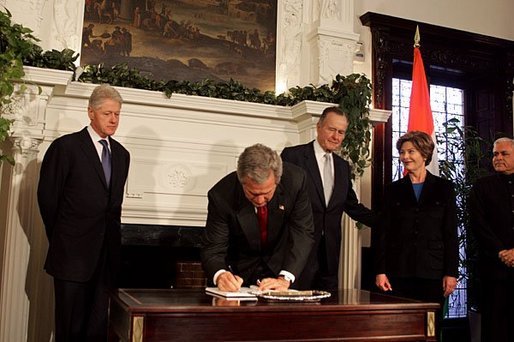 President George W. Bush signs a condolence book for the victims of the recent tsunami during a visit to the Embassy of India in Washington, D.C., Monday, Jan. 3, 2005. Also signing to express their condolences are Laura Bush and former Presidents Bush and Clinton. White House photo by Susan Sterner.