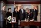 President George W. Bush signs a condolence book for the victims of the recent tsunami during a visit to the Embassy of Thailand in Washington, D.C., Monday, Jan. 3, 2005. Next to the book, stands a photograph of Khun Poom Jensen, 21. A grandson of Thailand's King Bhumibol Adulyadej, Mr. Jensen died in the tsunami. Also signing their condolences are Laura Bush and former Presidents Bush and Clinton. White House photo by Susan Sterner.